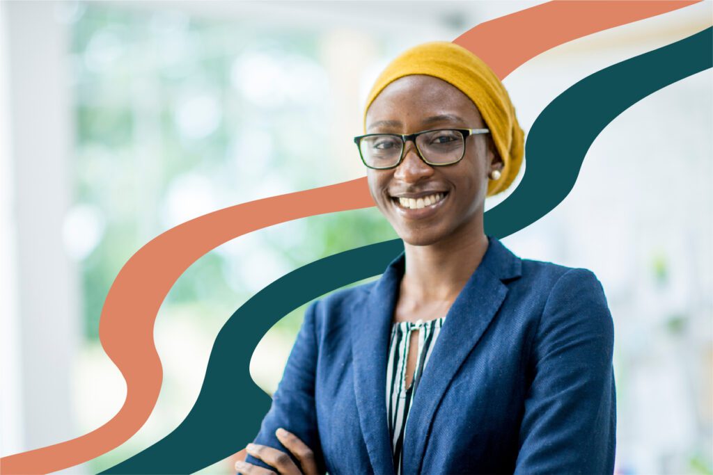 Smiling professional wearing glasses and a yellow head scarf.